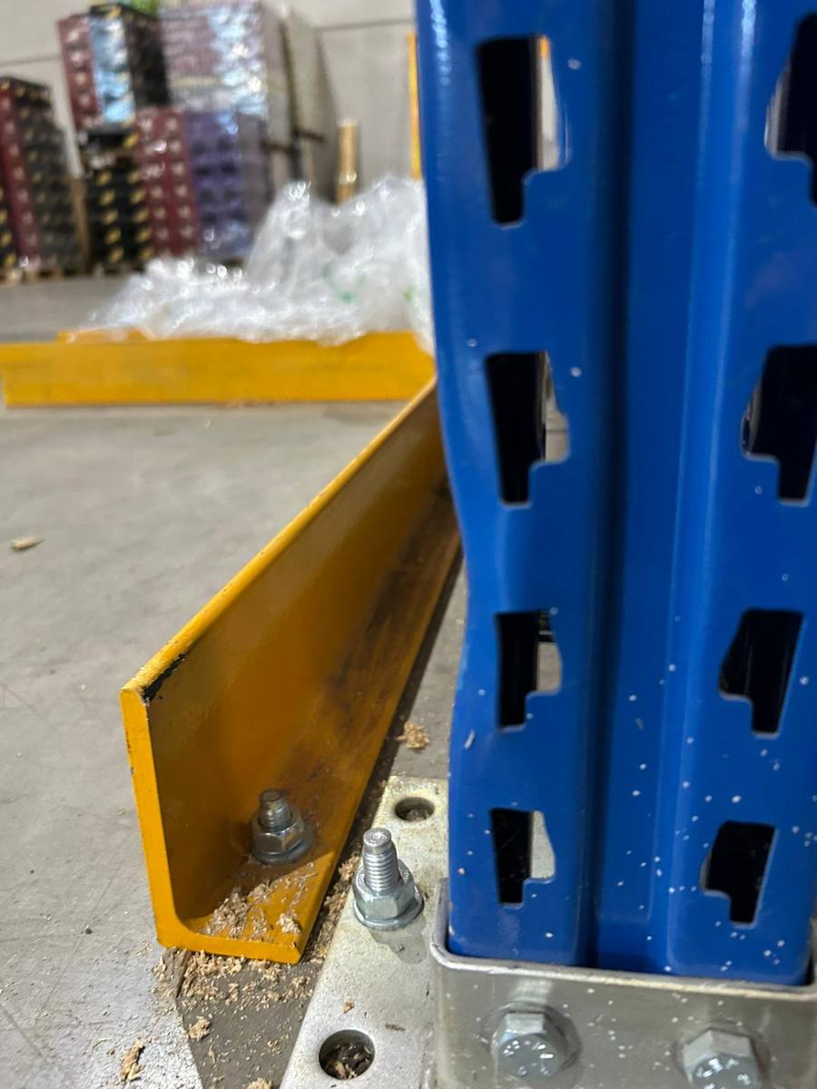 Beschädigter und gelöster Anfahrschutz an einem Regalständer im Lager